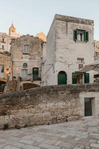 an old stone building with green doors and stairs at Ai Maestri Rooms&Cafè in Matera