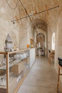 a large room with a stone wall and a counter with glasses at Ai Maestri Rooms&Cafè in Matera