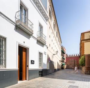 una calle en una ciudad con edificios blancos en La Puerta de Palacio - Adults Only en Sevilla