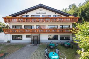 ein Gebäude mit Tischen und Stühlen davor in der Unterkunft Hotel Restaurant Haus Waldesruh in Eppenbrunn