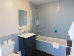 a bathroom with a sink, toilet and bathtub at Cullen Bay Hotel in Cullen