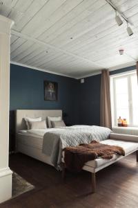 een slaapkamer met een groot bed met blauwe muren bij Stilleben Hotell in Åmot