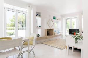 - un salon blanc avec une table et une télévision dans l'établissement Sea View Dreamy Penthouse in Vouliagmeni, à Athènes