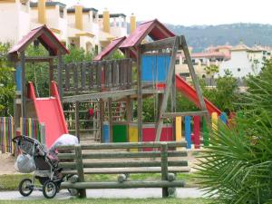 a playground with a stroller next to a bench at APCOSTAS - Atlanterra in Zahara de los Atunes