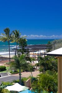 a view of a beach with palm trees and the ocean at Kacy's Bargara Beach Motel in Bargara