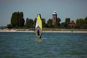 a person on a surfboard with a sail in the water at Herrmann Jens in Pelzerhaken