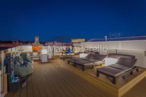 a deck with couches and chairs on a roof at Apartamentos Obelisc in Can Picafort