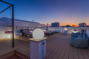 a deck with benches and a couch on a roof at Apartamentos Obelisc in Can Picafort