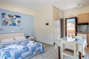 a bedroom with a bed and a table and a kitchen at Byron Hotel in Argostoli