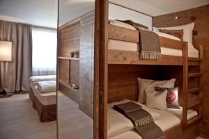 2 Etagenbetten in einem Zimmer mit Spiegel in der Unterkunft Ariston Dolomiti Residence in Toblach