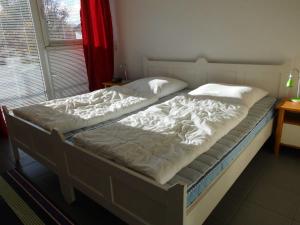 ペルツァーハケンにあるOstseeresidenz App 6のベッドルームに大型ベッド(白いシーツ付)
