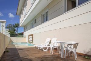 eine Terrasse mit Tisch und Stühlen neben einem Gebäude in der Unterkunft Hotel Hola in Florianópolis