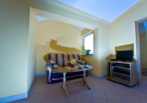 a living room with a couch and a table and a tv at Apartmani Ibolja in Promajna