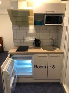 a kitchen with an open refrigerator and a sink at Liivalaia 40 cozy kitchen studio in Tallinn