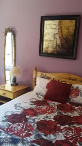 una camera da letto con un letto con una trapunta floreale sopra di Otentik guesthouse a Mbabane