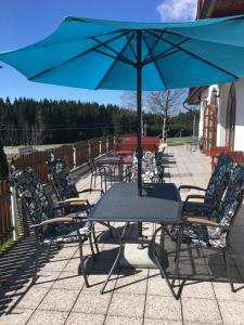 a table and chairs with an umbrella on a patio at Penzion Karlov in Karlov