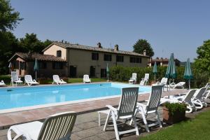 a pool with chairs and umbrellas in front of a house at Miralduolo in Ponte San Giovanni