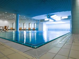 einem Pool in einem Gebäude mit blauer Decke in der Unterkunft Park Hotel Zug in Zug