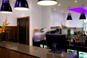 a woman sitting at a bar in a restaurant at The Z Hotel Liverpool in Liverpool