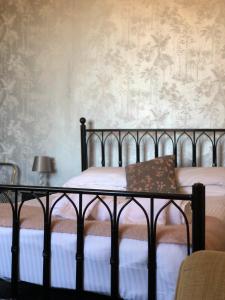 a bedroom with a bed and a wall with wallpaper at The Dorset in Lewes