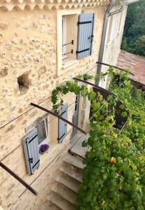 uma escada que leva a um edifício com janelas e flores em Gites Lydil em Nyons