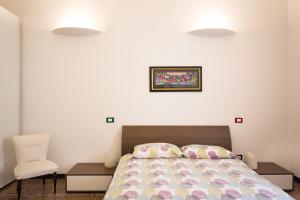 a bedroom with a bed and a chair and two lights at A Beautiful House in Genoa in Genoa