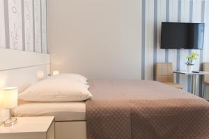 sypialnia z łóżkiem i telewizorem na ścianie w obiekcie Villa Natalia am See w mieście Friedrichshafen