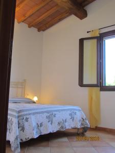 a bedroom with a bed with a blue blanket at Appartamenti i Tigli in Capoliveri