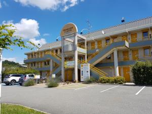 un hôtel avec des escaliers jaunes dans un parking dans l'établissement Premiere Classe Belfort, à Belfort