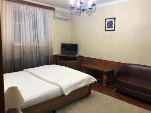 マハチカラにあるHotel Usadbaのベッドルーム(ベッド1台、ソファ、テレビ付)