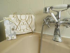 a bathroom sink with a faucet and a towel at Guesthouse La maison de Fille in Diest