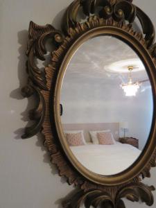 a mirror on a wall with a bed in a room at Guesthouse La maison de Fille in Diest