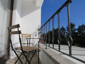 a pair of chairs sitting on a balcony at Guesthouse La maison de Fille in Diest