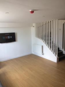 an empty living room with a stair case and a stair at Nestin Liverpool in Liverpool