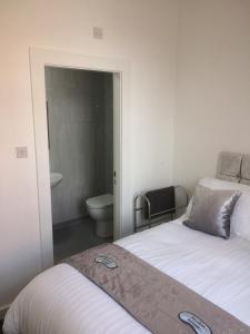 a bedroom with two beds and a bathroom with a toilet at Nestin Liverpool in Liverpool