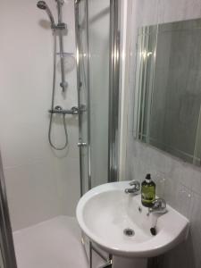 a white bathroom with a sink and a shower at Nestin Liverpool in Liverpool