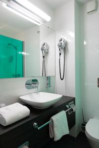 a bathroom with a sink and a phone on the wall at Akena Nantes Atlantis Zénith in Saint-Herblain