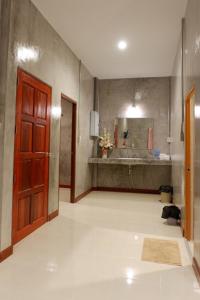 a bathroom with a sink and a red door at โรงแรมโทนี่วิลเลจTony Hotel in Phatthalung