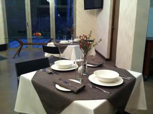 a table with plates and utensils on top of it at Hudson House in Pretoria