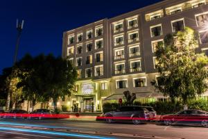 un bâtiment avec des voitures garées devant lui dans l'établissement Le Casablanca Hotel, à Casablanca