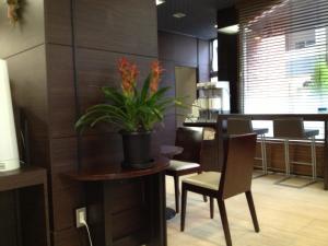 ein Esszimmer mit einem Tisch und einer Topfpflanze in der Unterkunft Hotel Horidome Villa in Tokio