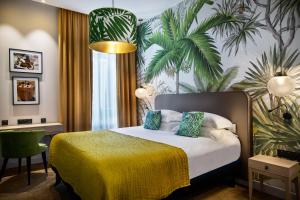 a hotel room with a bed with a yellow blanket at Hotel Verlaine in Cannes