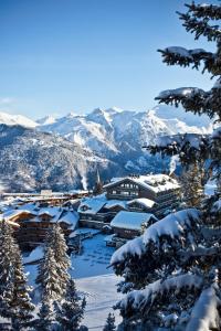 クールシュヴェルにあるLe Lanaの山々を背景に雪に覆われた町