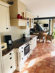 a kitchen with white cabinets and a tile floor at "Schiffszimmermannshaus" by Ferienhaus Strandgut in Born