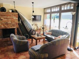 ein Wohnzimmer mit zwei Sofas und einem Kamin in der Unterkunft "Schiffszimmermannshaus" by Ferienhaus Strandgut in Born