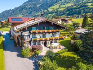 a house in the mountains with flowers on it at Landhaus & Appartementhaus Haussteiner in Dorfgastein