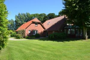 a house with a green yard in front of it at Austernfischer in Reitland