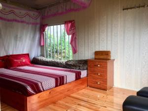a bedroom with a bed with a dresser and a window at Ta Van Heaven Homestay in Sa Pa