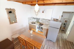 a kitchen with a table and a refrigerator at Greenside Cottage Lumi in Vela Luka