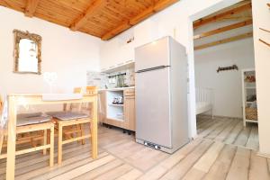 a kitchen with a refrigerator and a table at Greenside Cottage Lumi in Vela Luka